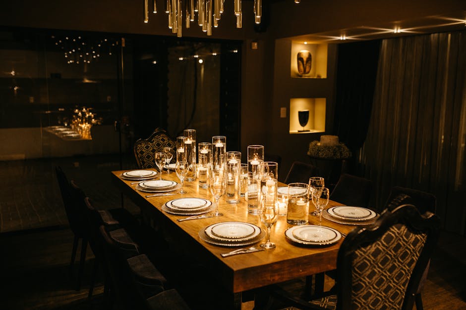 A dining table with candles lit and a chandelier